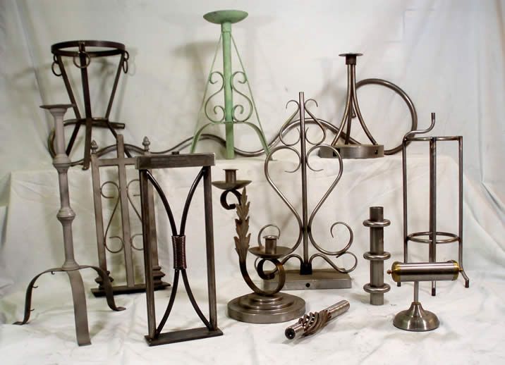 A collection of various fabricated metal stands of different shapes and sizes arranged on a white background.